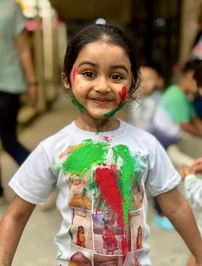 Child smiling during Holi celebrations at Paramount Grove