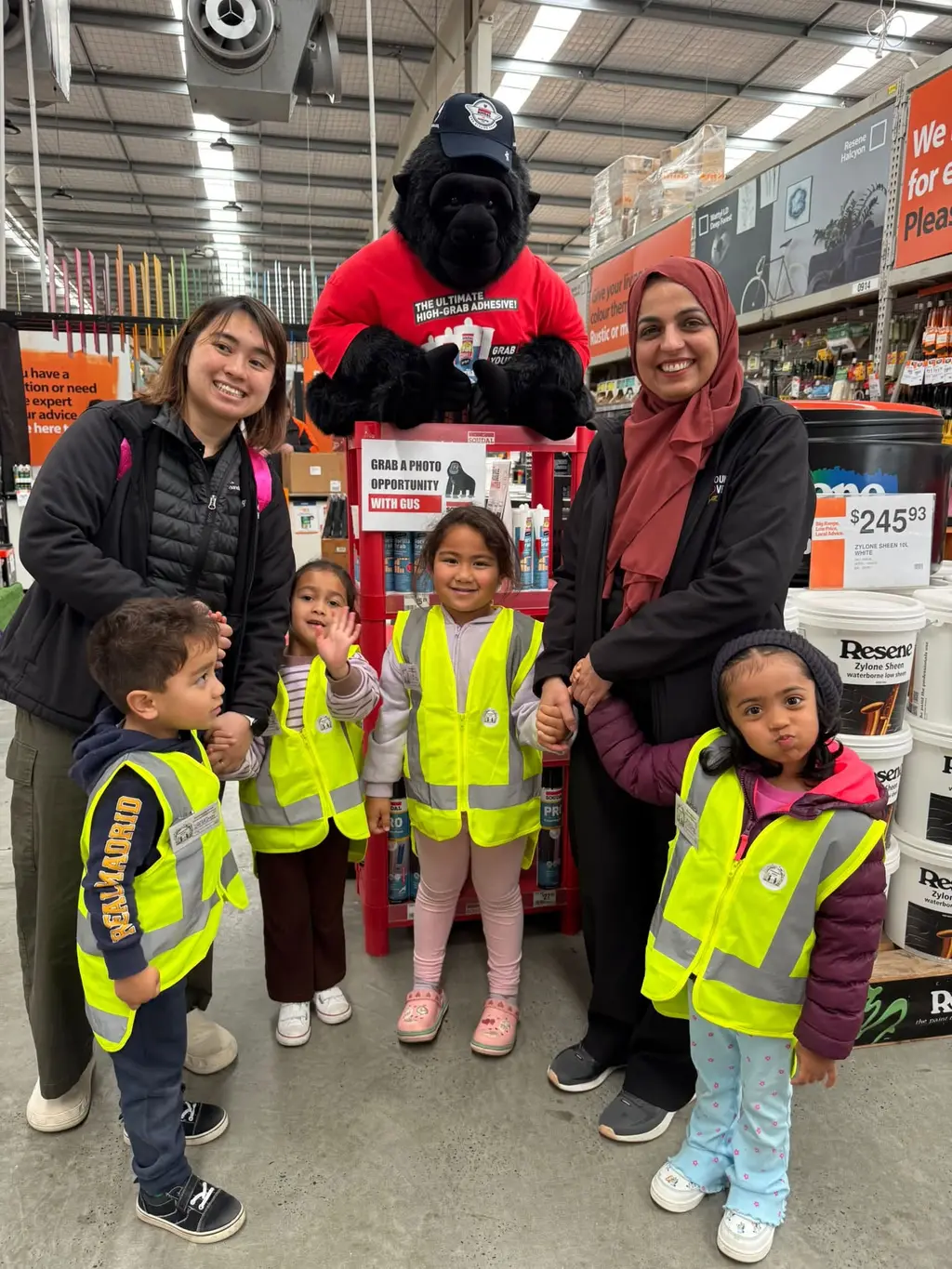 Preschoolers in high-visibility vests with kaiako during their Mitre 10 visit