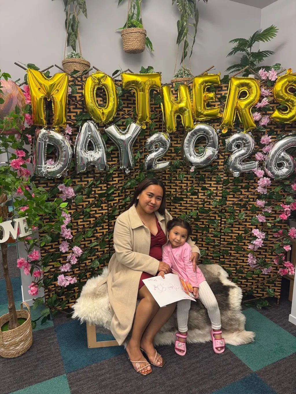 A mother and child posing together during Paramount Grove's Mother's Day celebration.