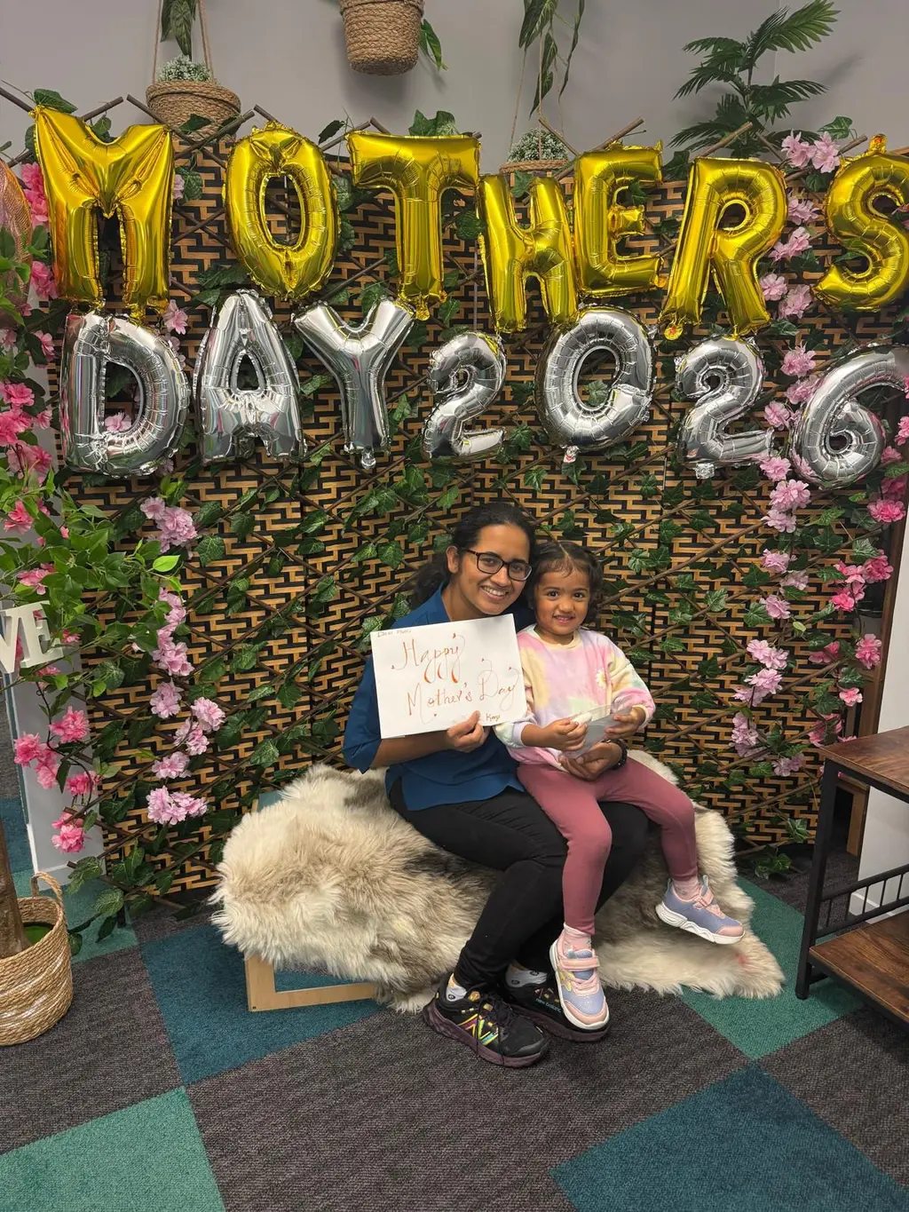 A caregiver and child holding a handmade gift during the Mother's Day celebration at Paramount Grove.