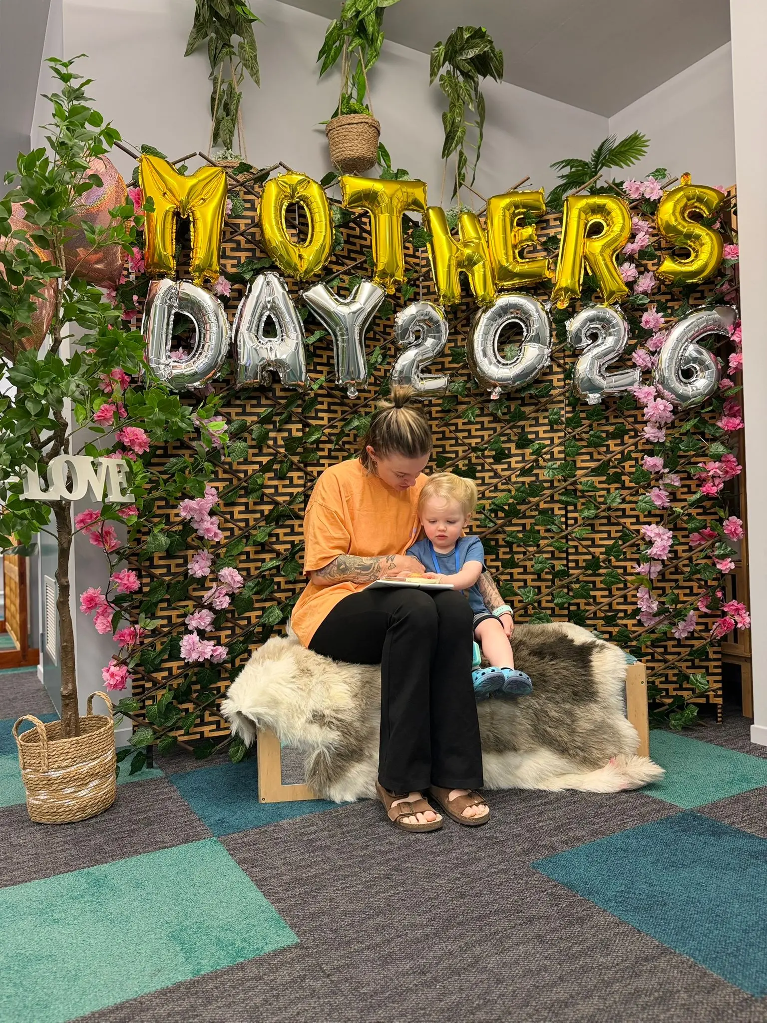 A mother and child sharing a quiet moment together in front of Paramount Grove's Mother's Day display.
